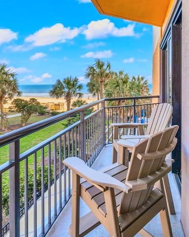 Bright oceanfront living room with fireplace and balcony view